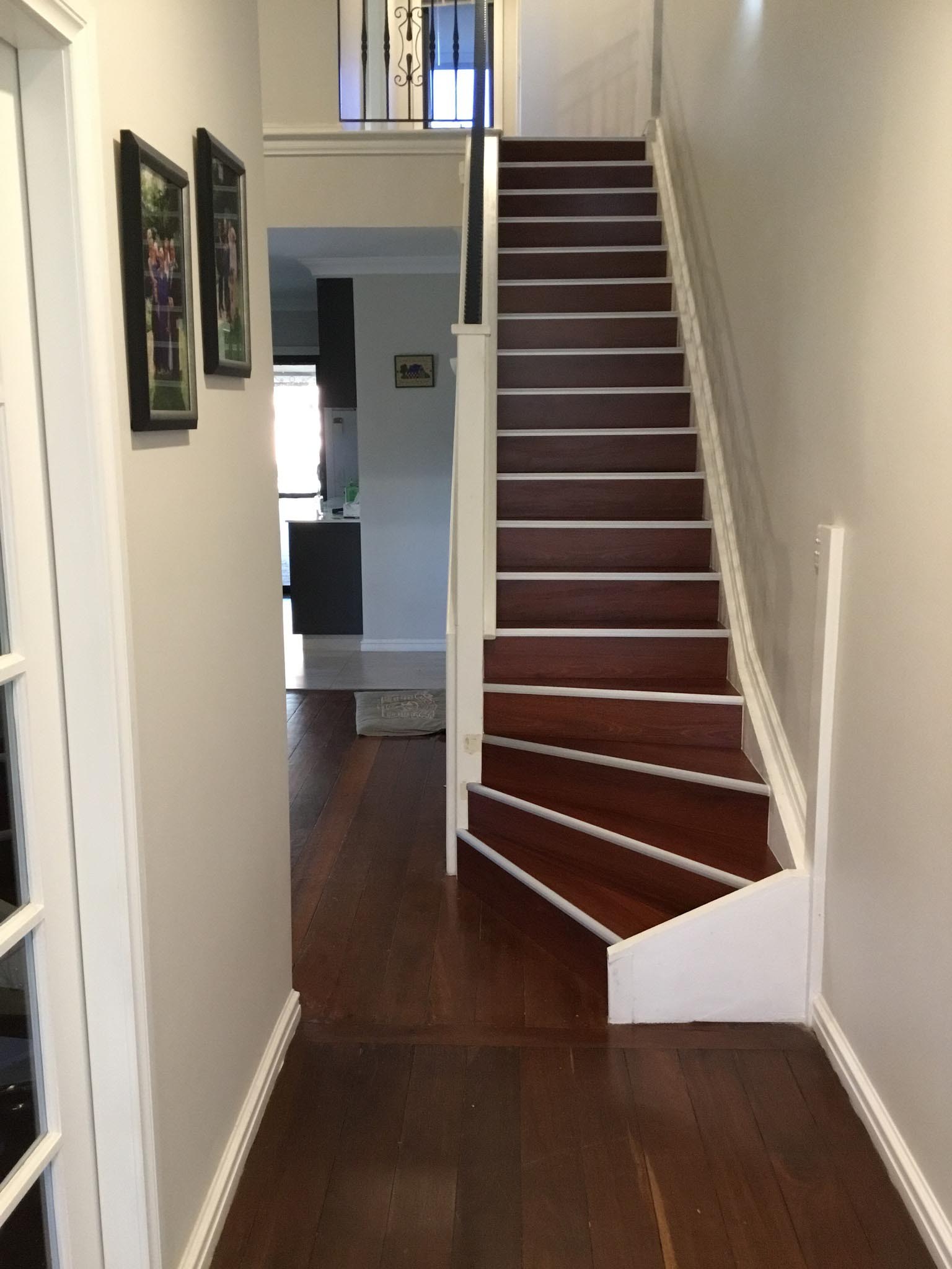 1b-home-about2 Hallway leading to a staircase with dark timber treads and white risers